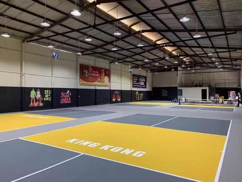 Facility staff performing routine maintenance on PVC sports flooring court lines